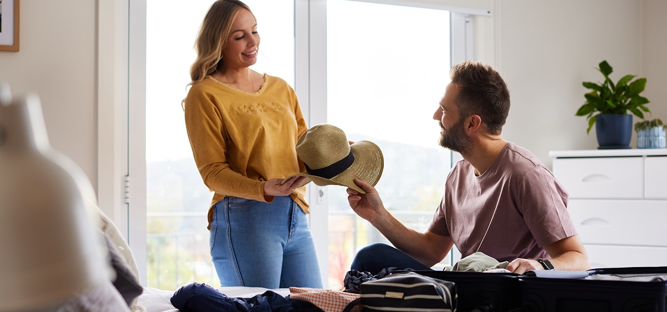 Young couple sorting through clothes in the bedroom