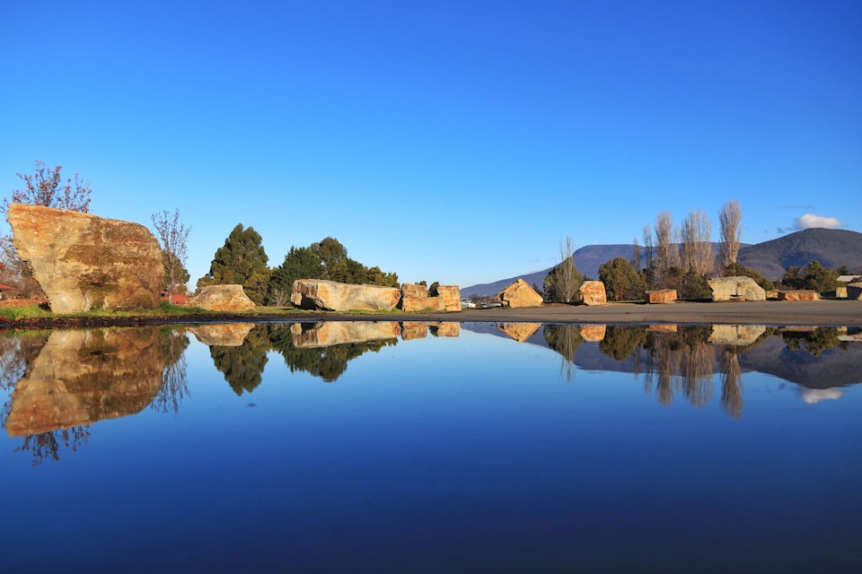 Perfect reflection in a lake of Mount Wellington and positioned boulders