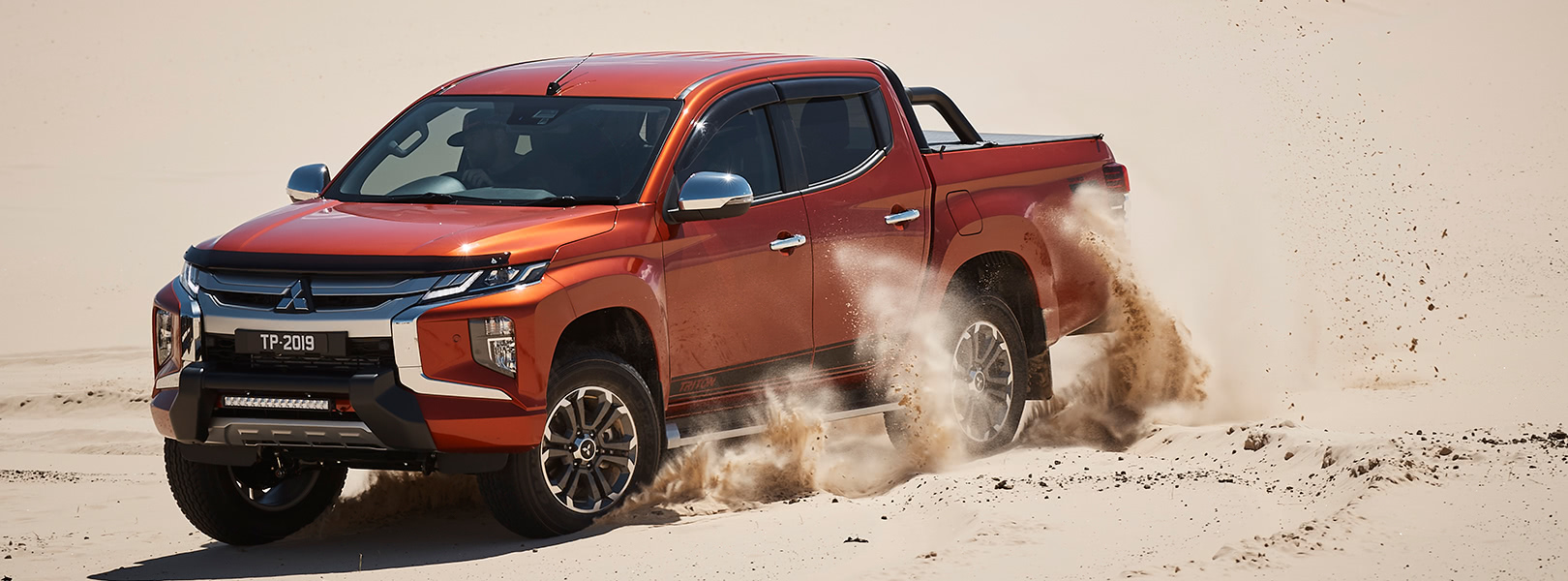 Mitsubishi Triton driving on sand