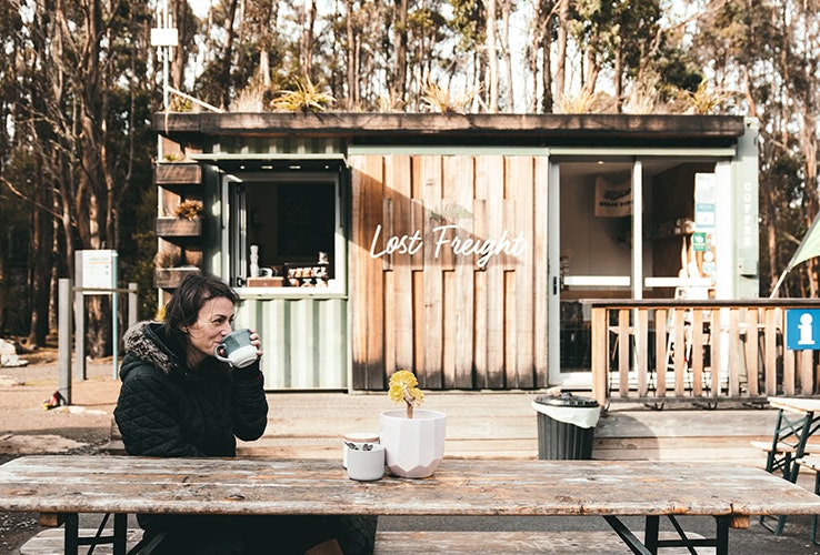Person enjoying coffe at an outdoor cafe.
