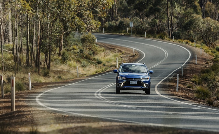 Blue Mitsubishi driving along rural road