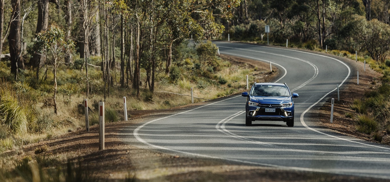 Blue Mitsubishi driving along rural road