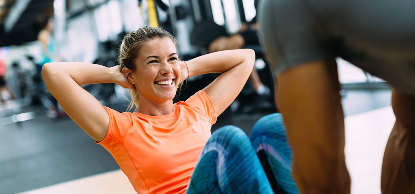 Young lady doing sit-ups in the gym