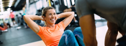Young lady doing sit-ups in the gym