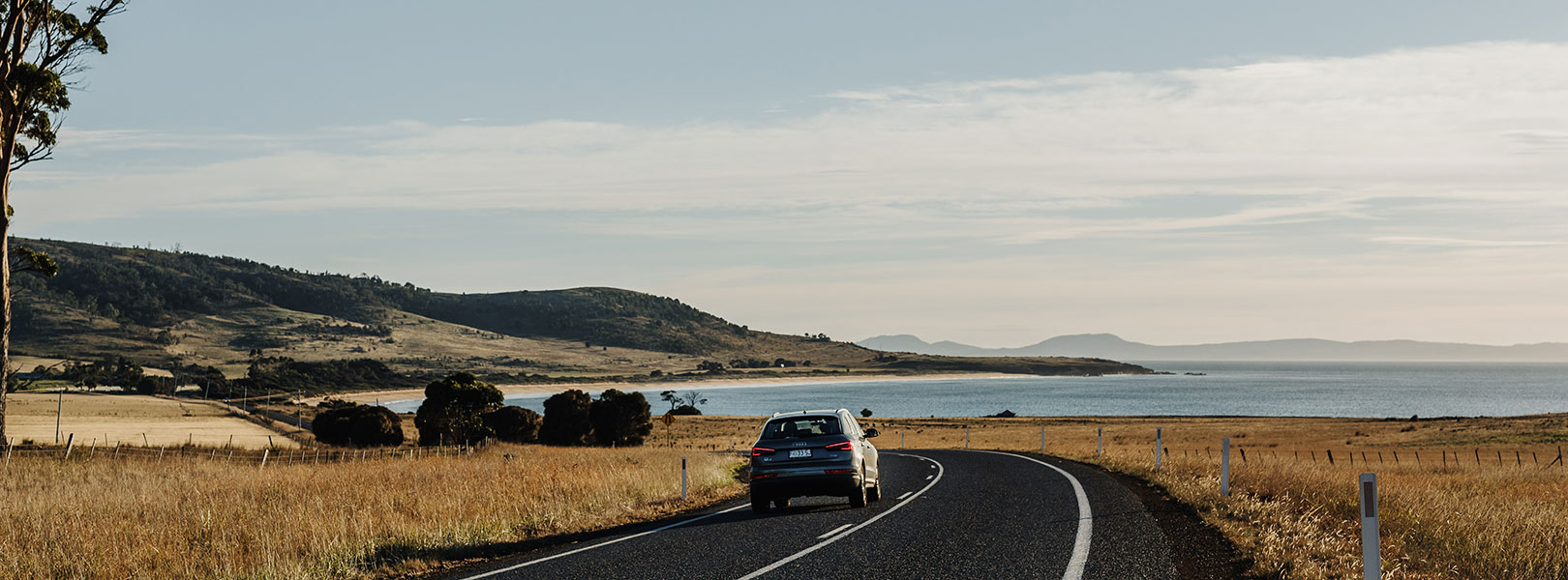 Car driving through a seaside road.