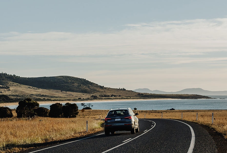 Car driving through a seaside road.