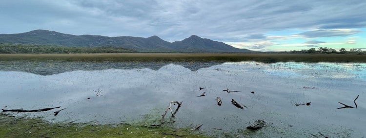A view of a mountain range from the mouth of a lake.