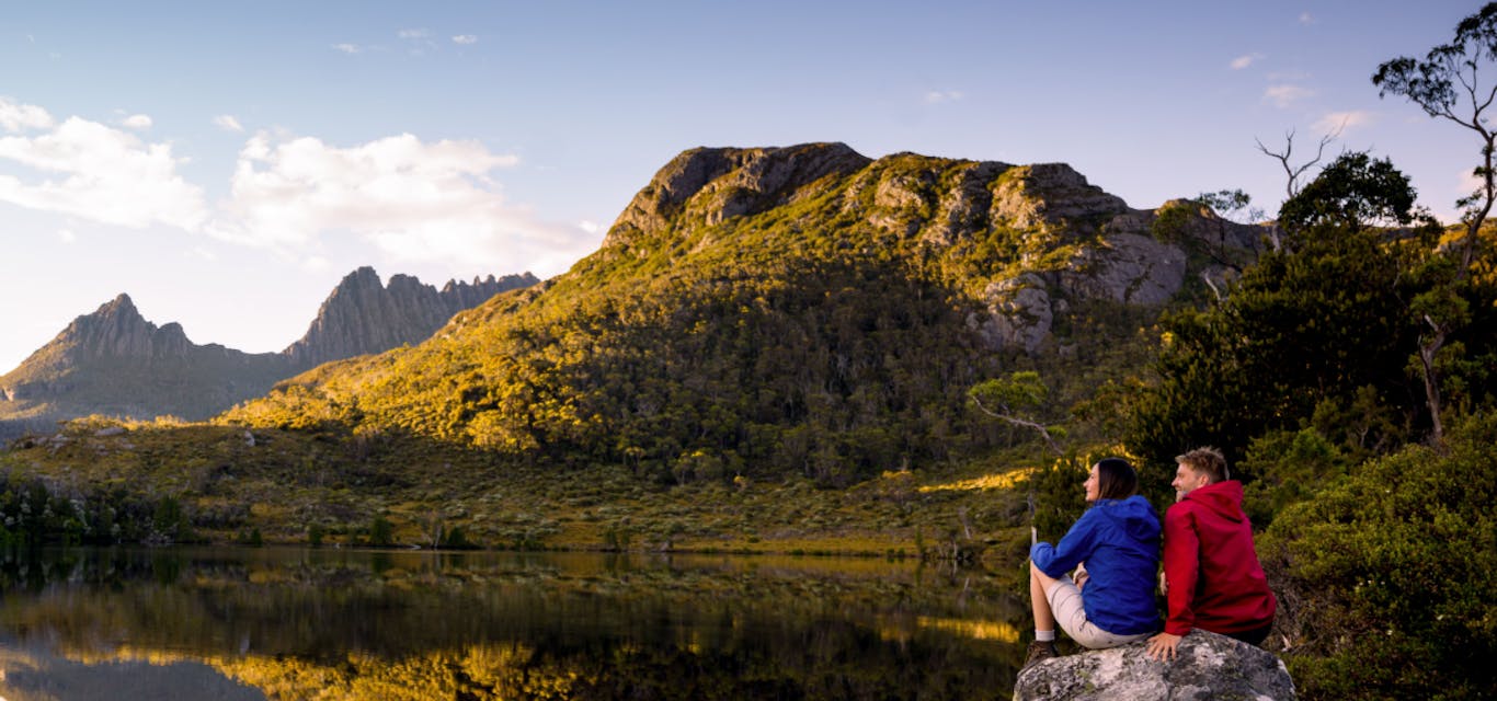 Young couple looking over lake to Cradle Mountain Young couple looking over lake to Cradle Mountain