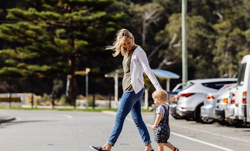 Woman and child crossing the road holding hands