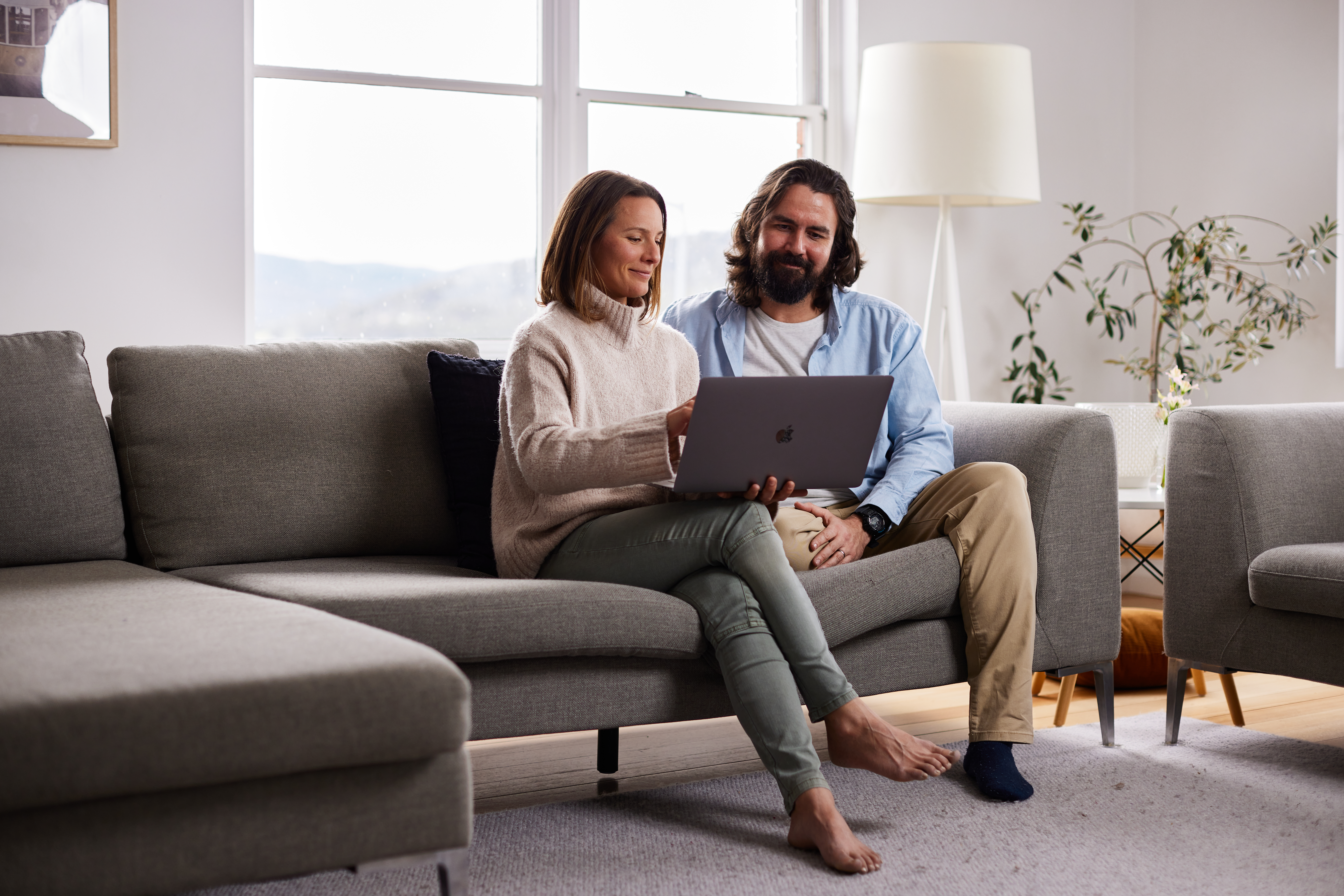 A couple on the couch sharing a laptop