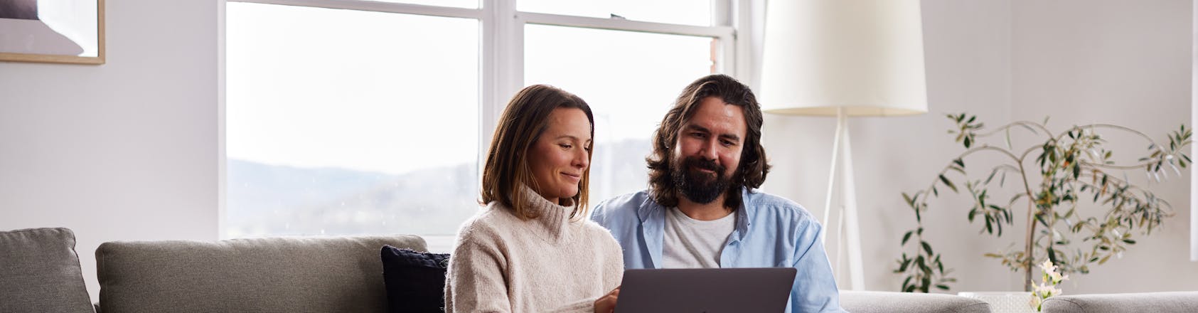 A couple on the couch sharing a laptop