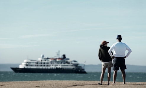 Two people looking at a cruise ship