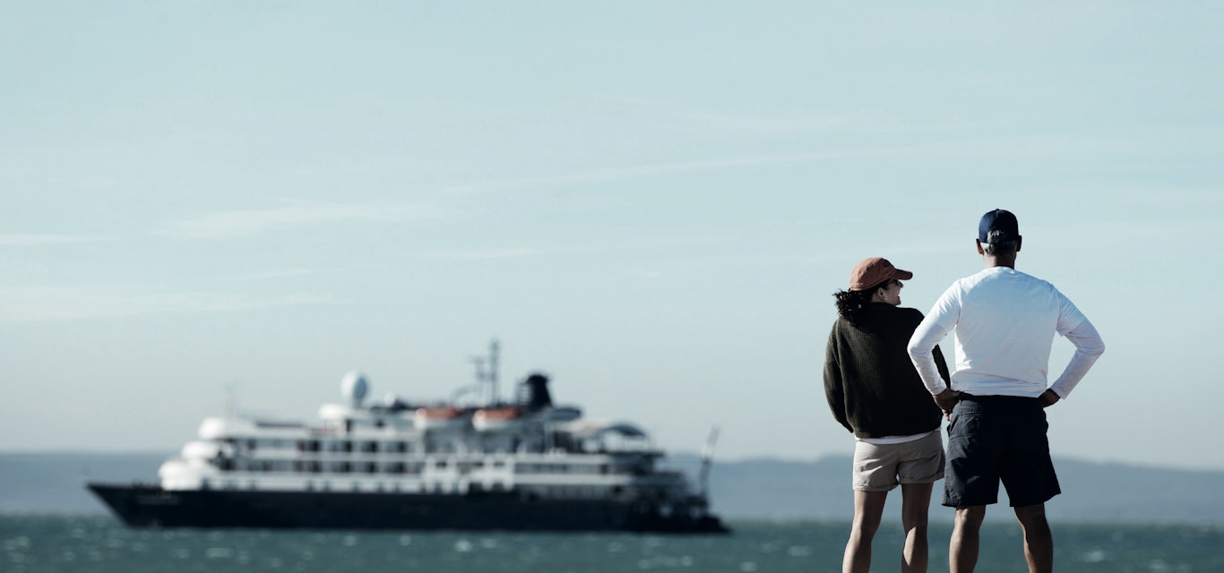 Two people looking at a cruise ship