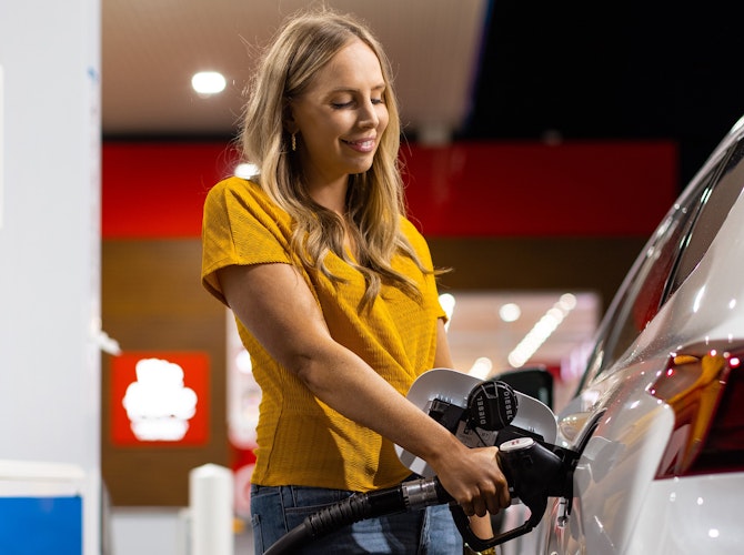 Woman filling car with fuel