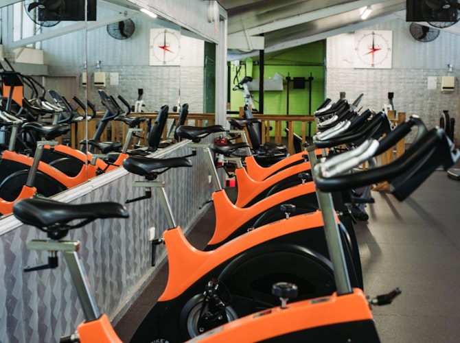 Orange exercise bikes in gym