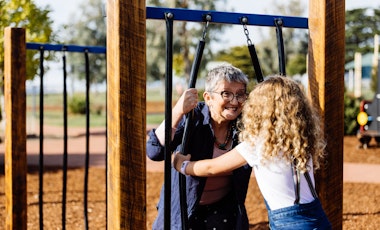Gran and child playing peek a boo at the park