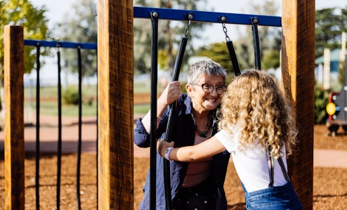Gran and child playing peek a boo at the park