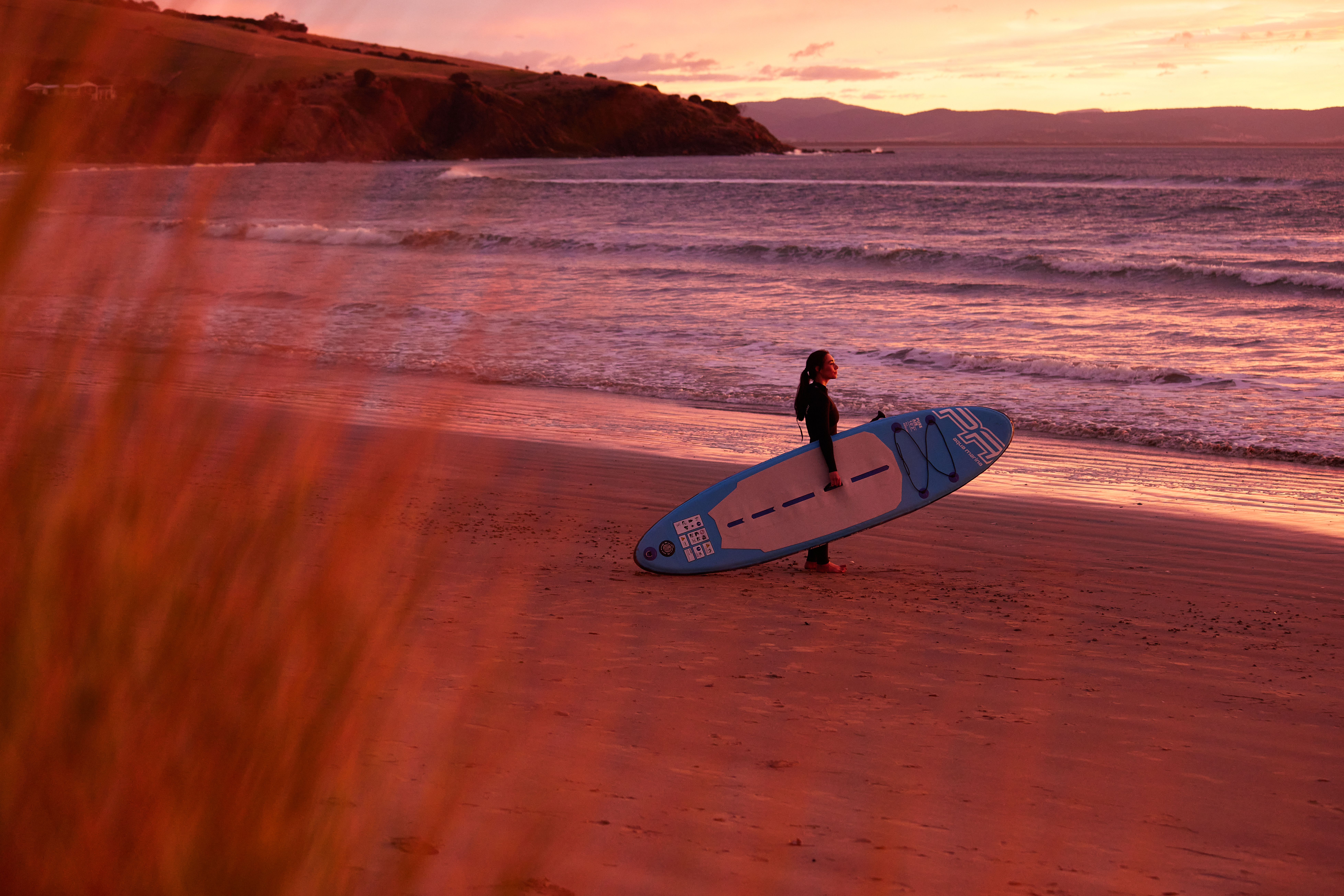 Getting ready to surf at sunrise on the beach.