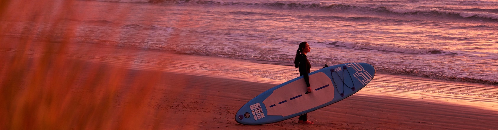 Getting ready to surf at sunrise on the beach.