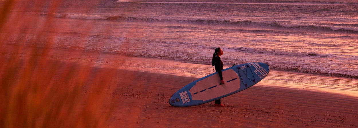 Getting ready to surf at sunrise on the beach.
