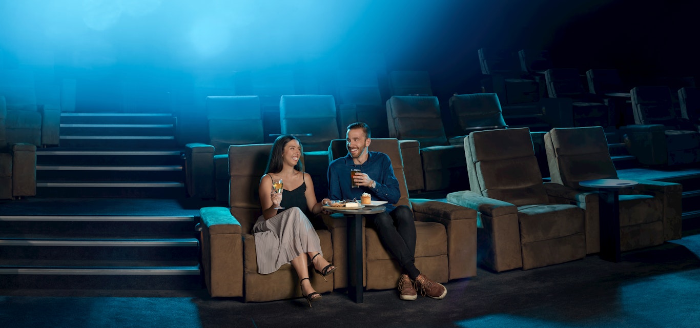 Give the gift of an experience. Couple sitting in gold class at Village cinemas.