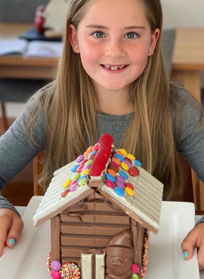 Young girl with Christmas Kit Kat house.