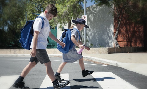 children crossing the road at a zebra crossing