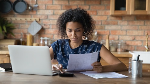 Woman sitting at laptop calculating bills