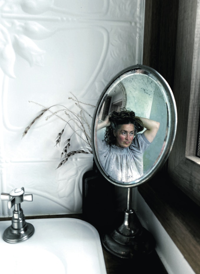 woman doing hair in mirror