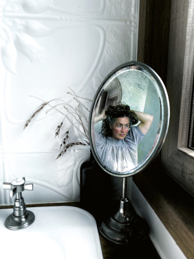 woman doing hair in mirror