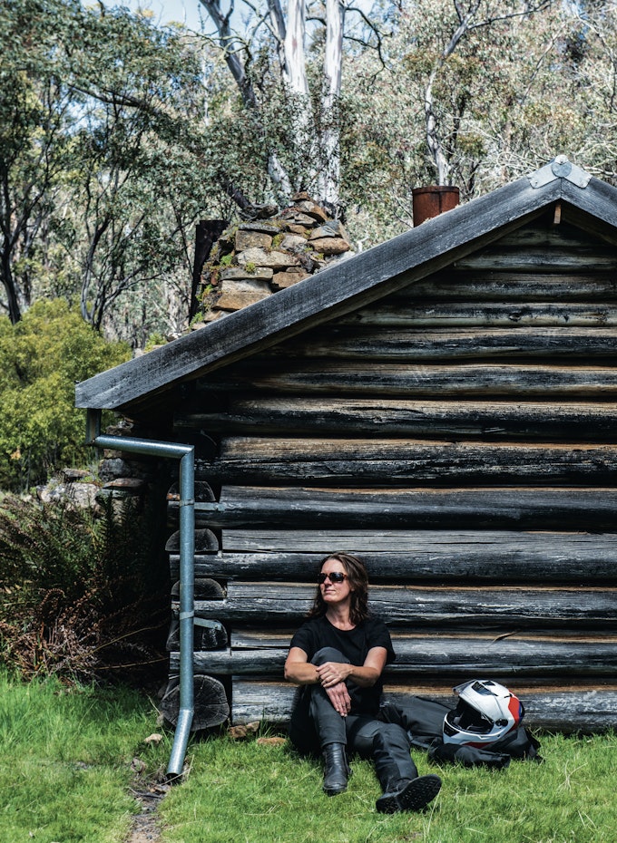 woman sitting next to hut