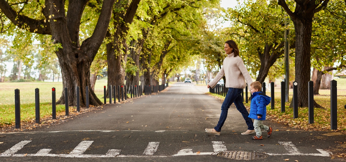 woman walking child across road