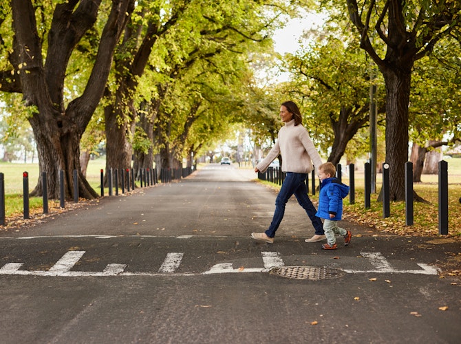 woman walking child across road