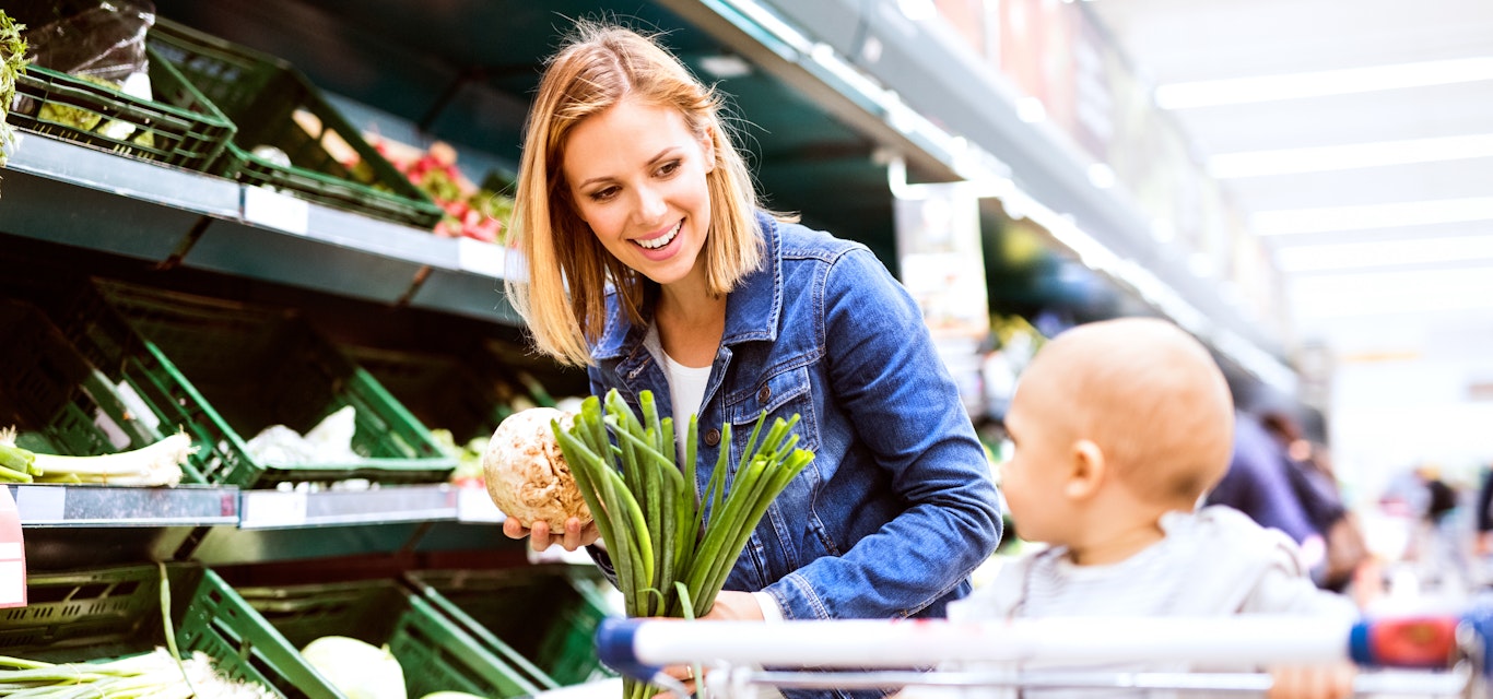 Woman grocery shopping with infant son 