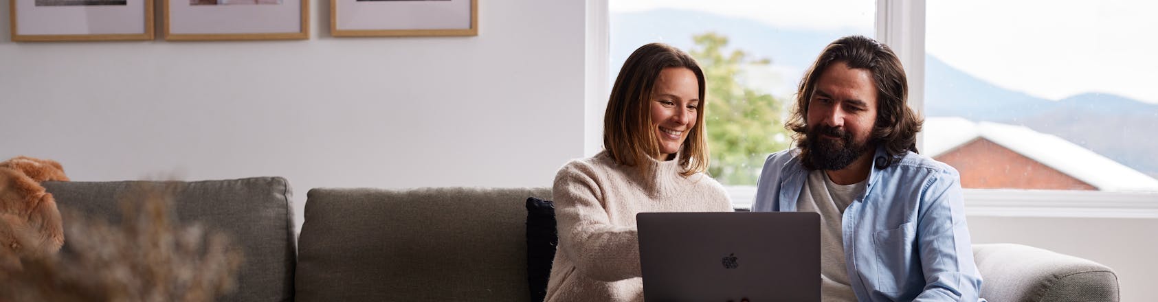 couple looking at laptop on couch