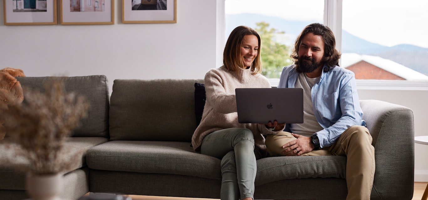 couple looking at laptop on couch