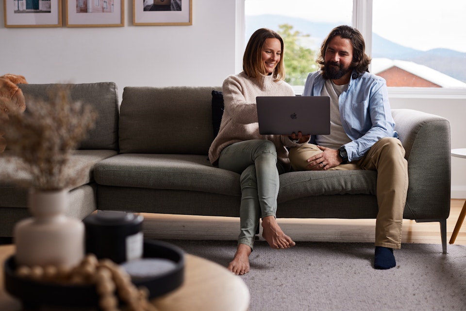 couple looking at laptop on couch