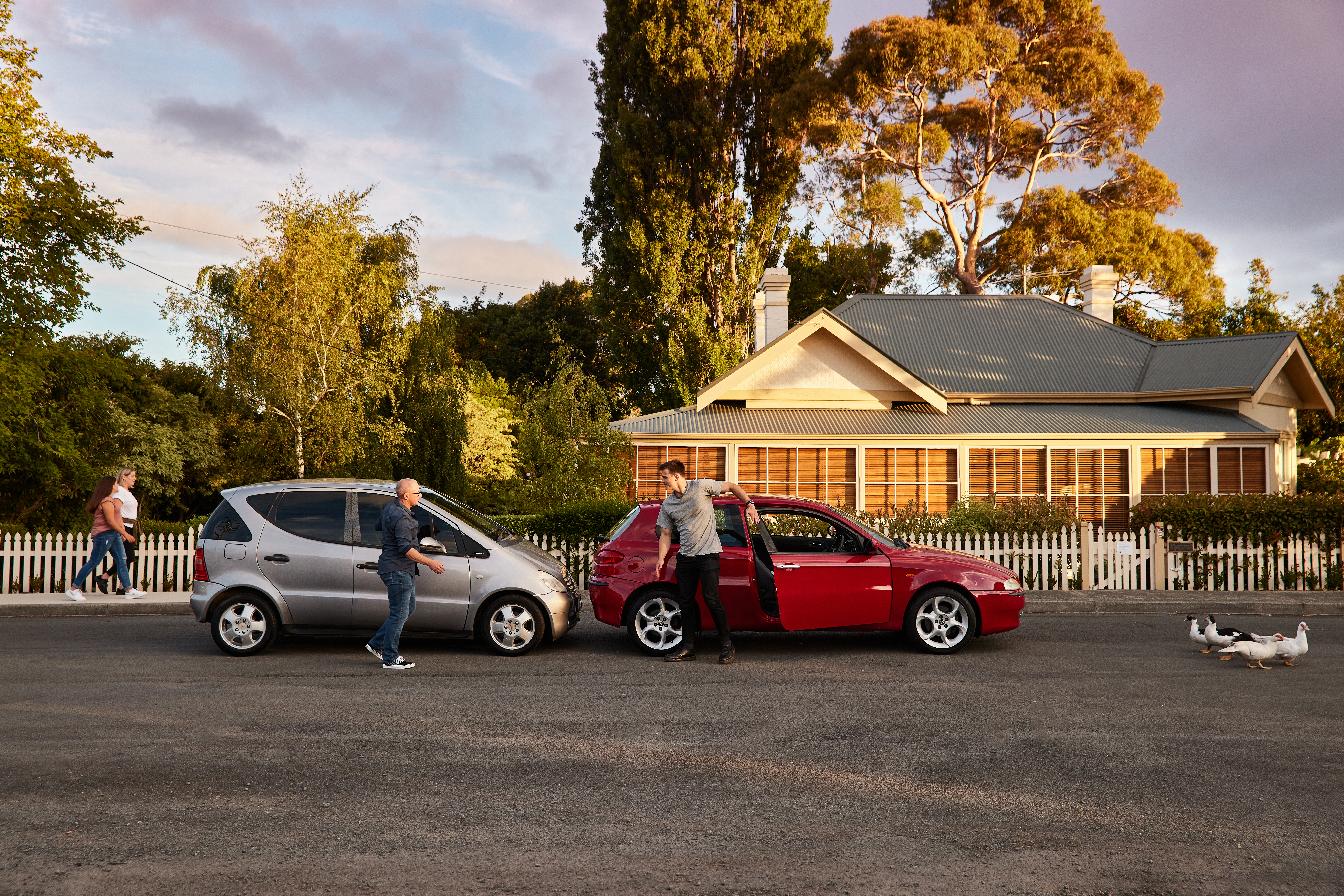 Two men talking beside cars after an accident.