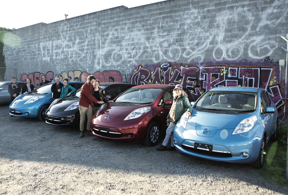 people standing next to electric cars