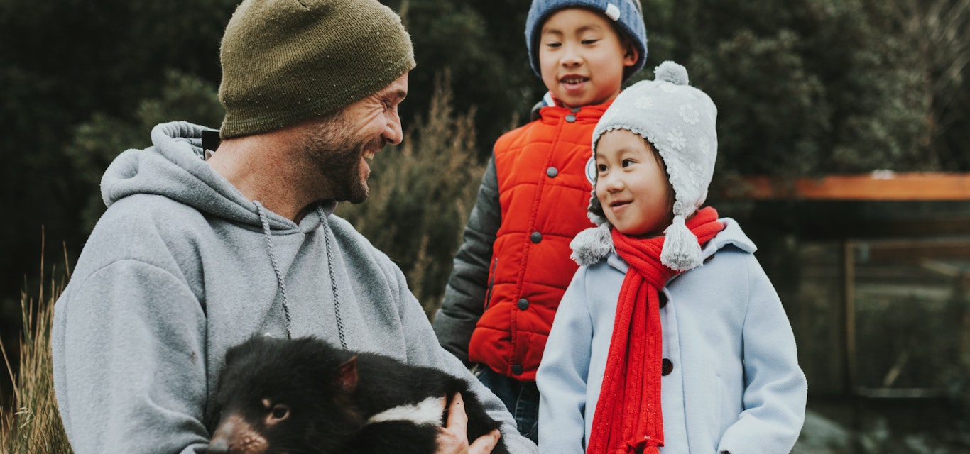 Get up close to wildlife at Devils Cradle Mountain family holding tassie devil
