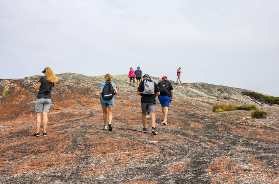 people walking up rock