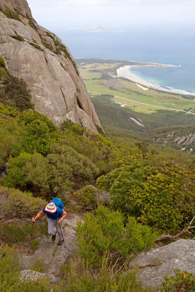hiker going up hill overlooking flinders island beach