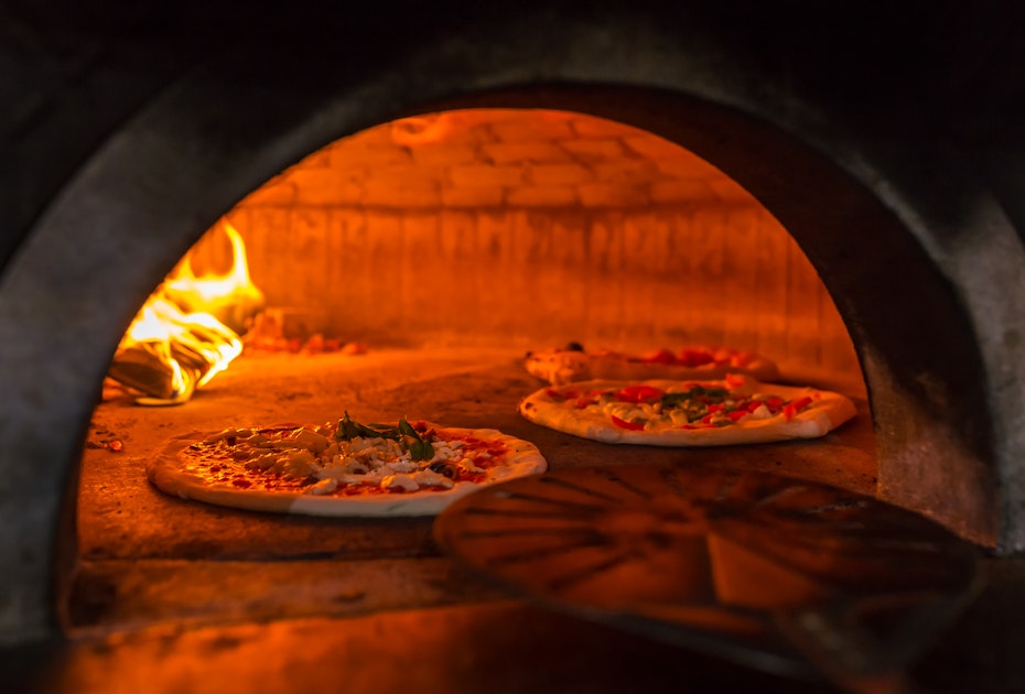 Pizza cooking in woodfired pizza oven 