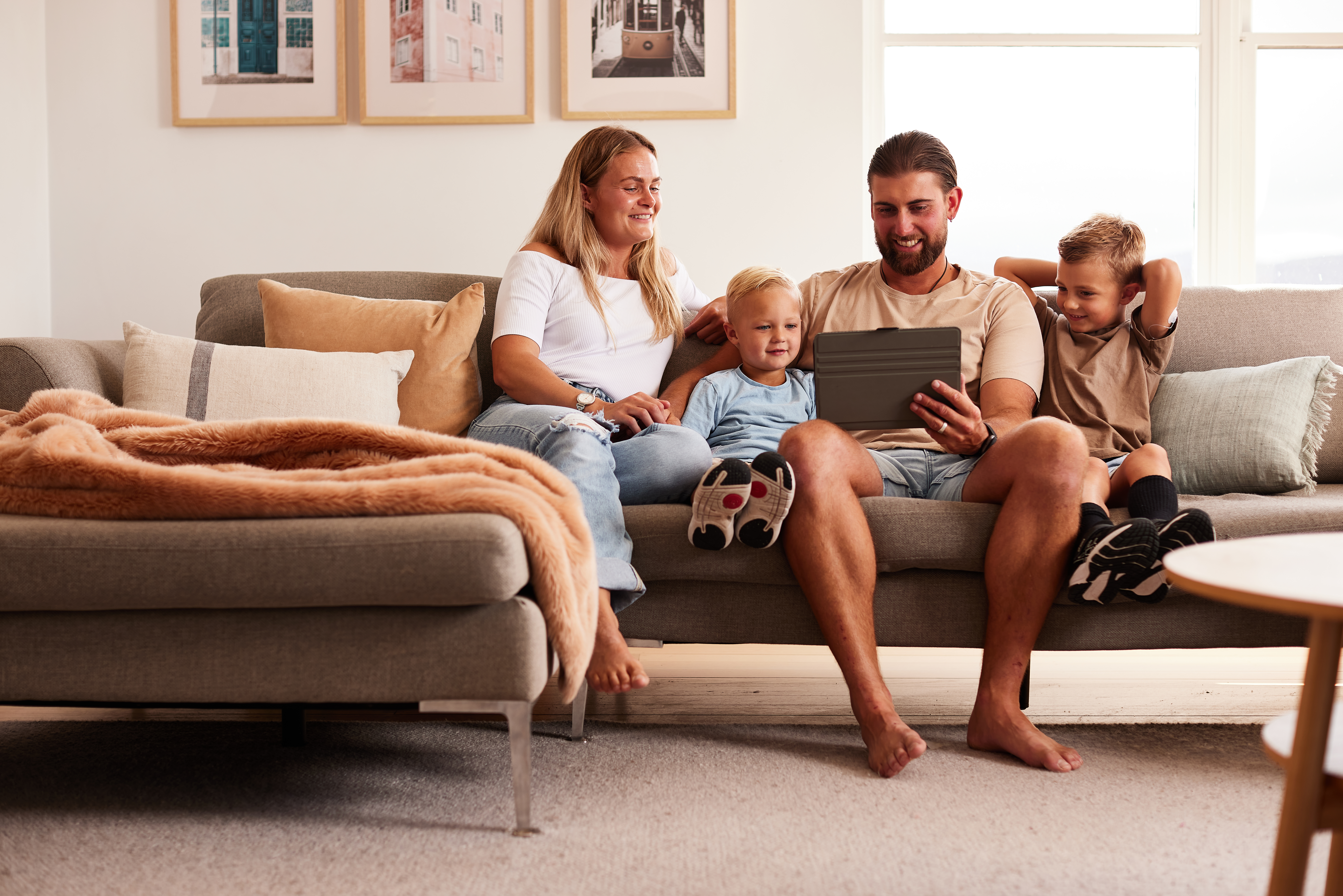 family on couch looking at tablet