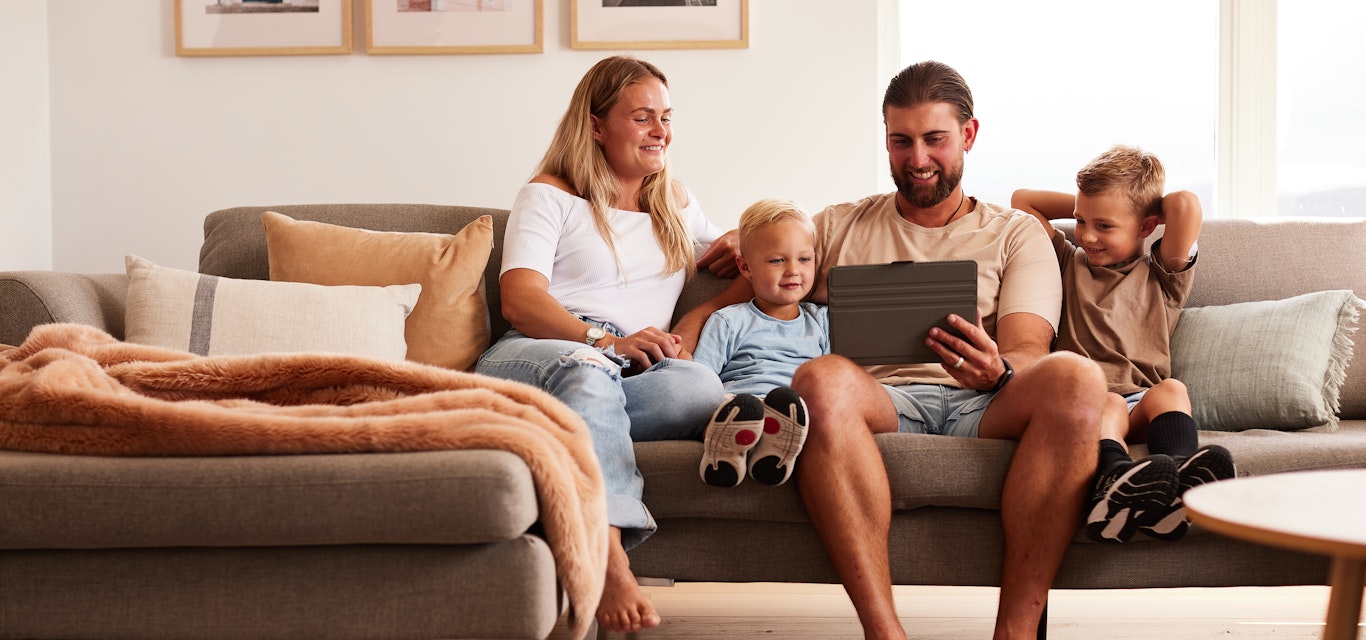 family on couch looking at tablet