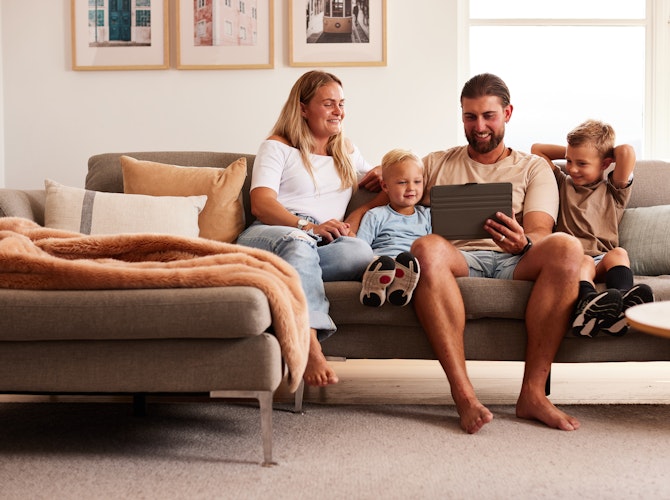 family on couch looking at tablet