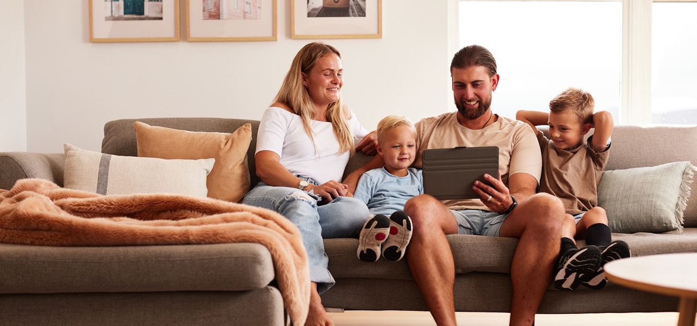 family on couch looking at tablet