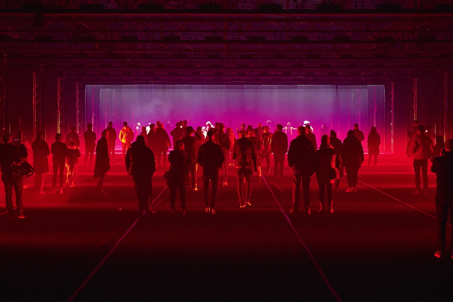 people standing in dark shed with red and pink lighting