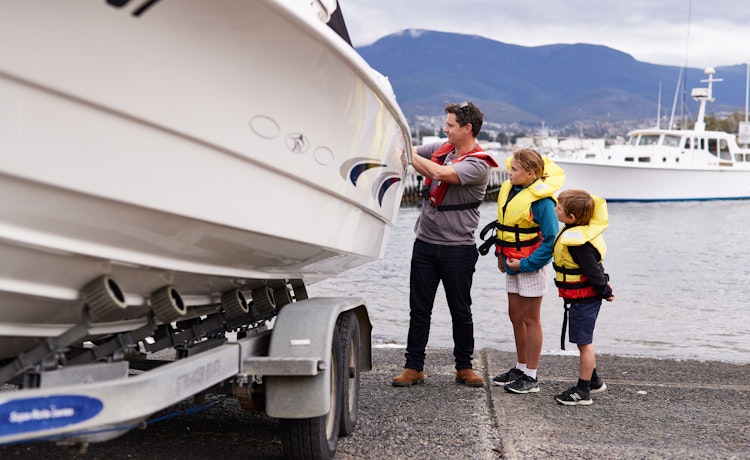 Man and two children preparing to launch their boat at the dock