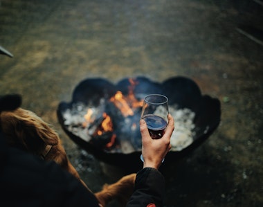 drinking red wine by fire pit